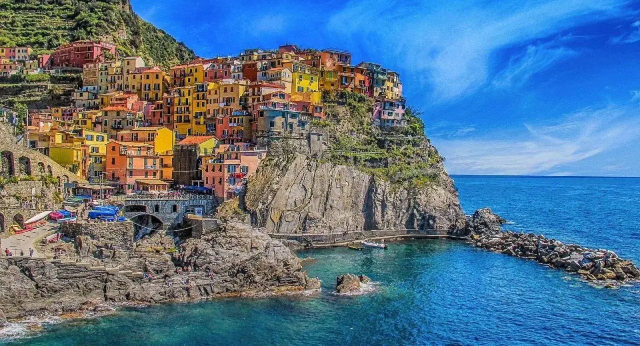 Village coloré accroché à la falaise, vue sur la mer bleue de Cinque Terre.