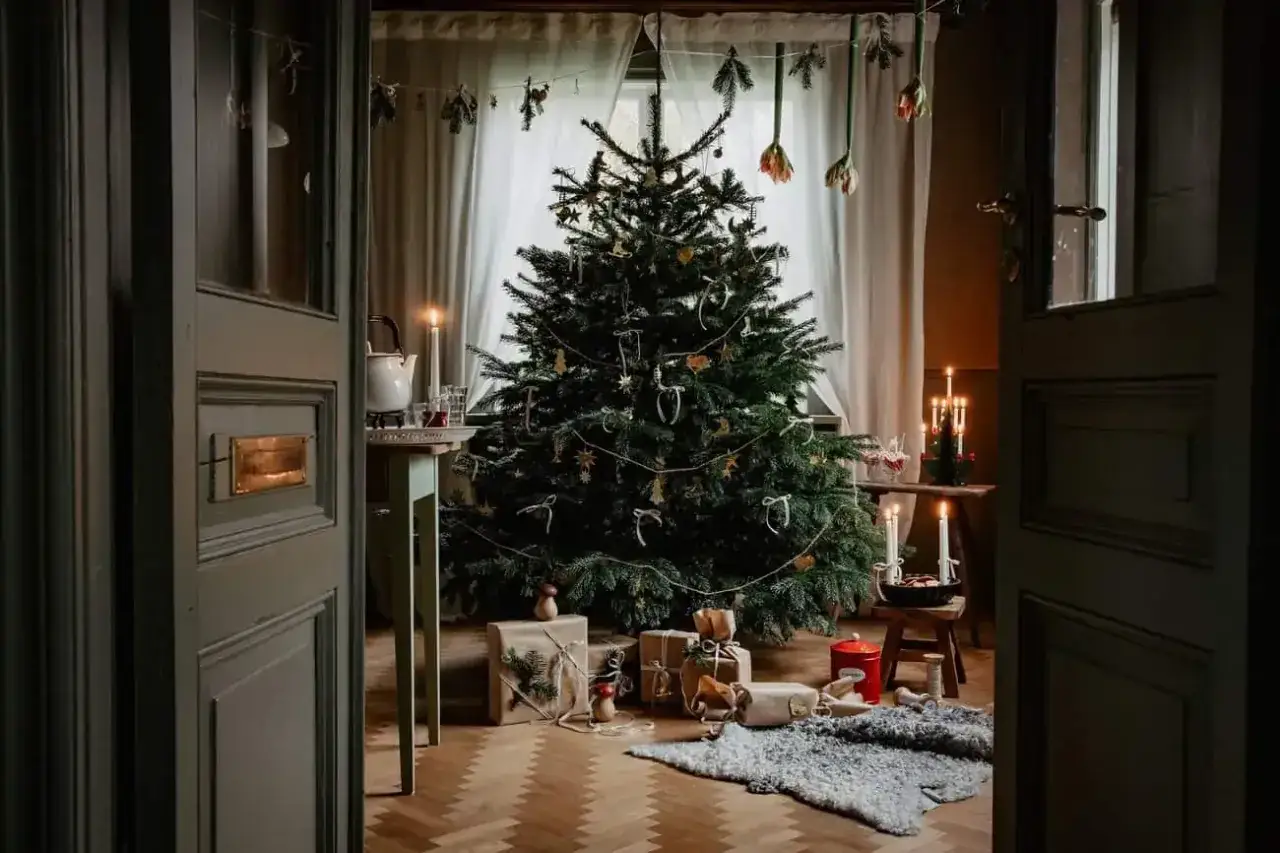 Mysig inredning jul med gran, presenter och levande ljus. En varm och inbjudande julstämning.