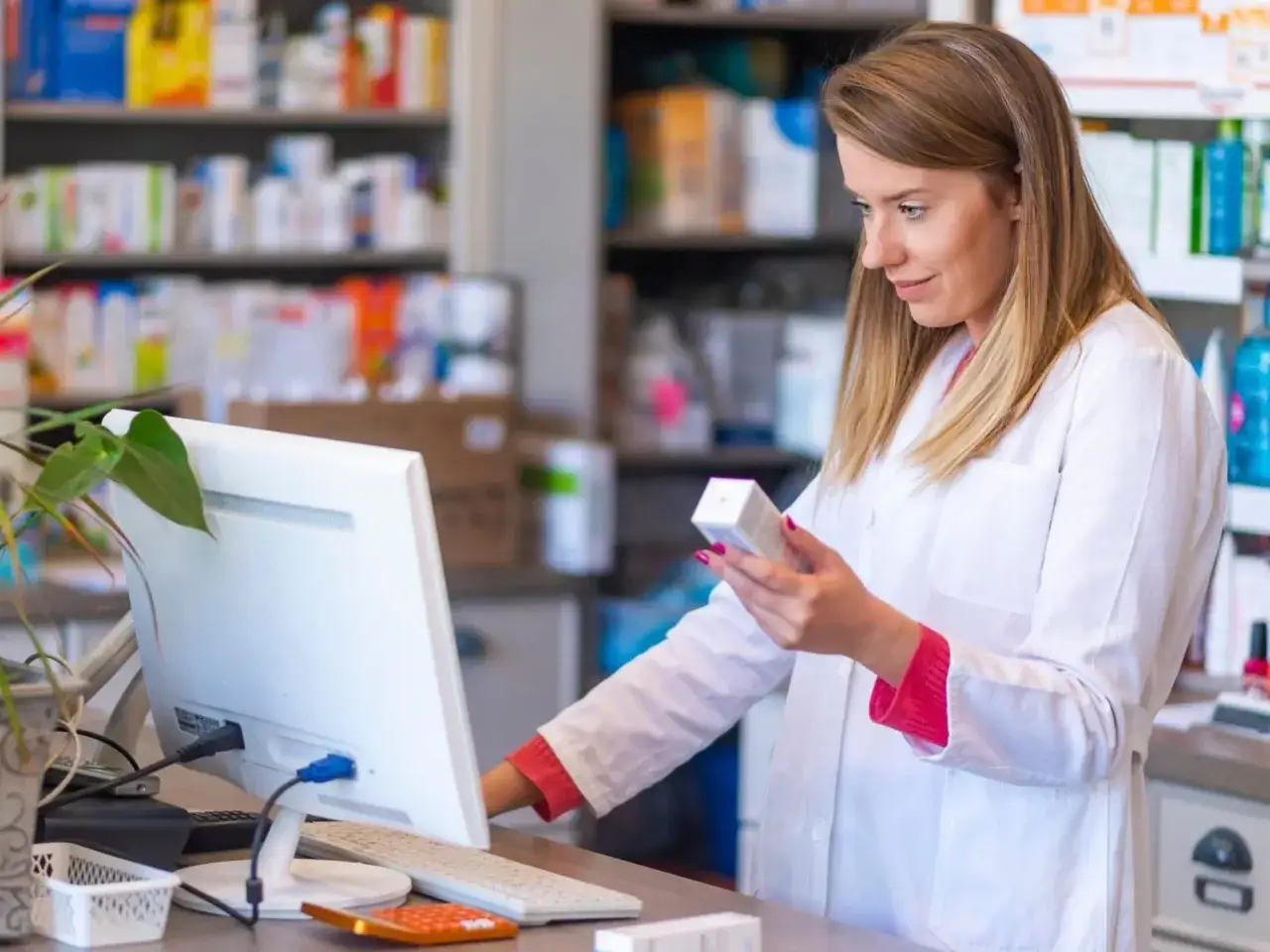 Farmaceutka sprawdza opakowanie globulek dopochwowych przeciwgrzybiczych i przeciwbakteryjnych bez recepty.
