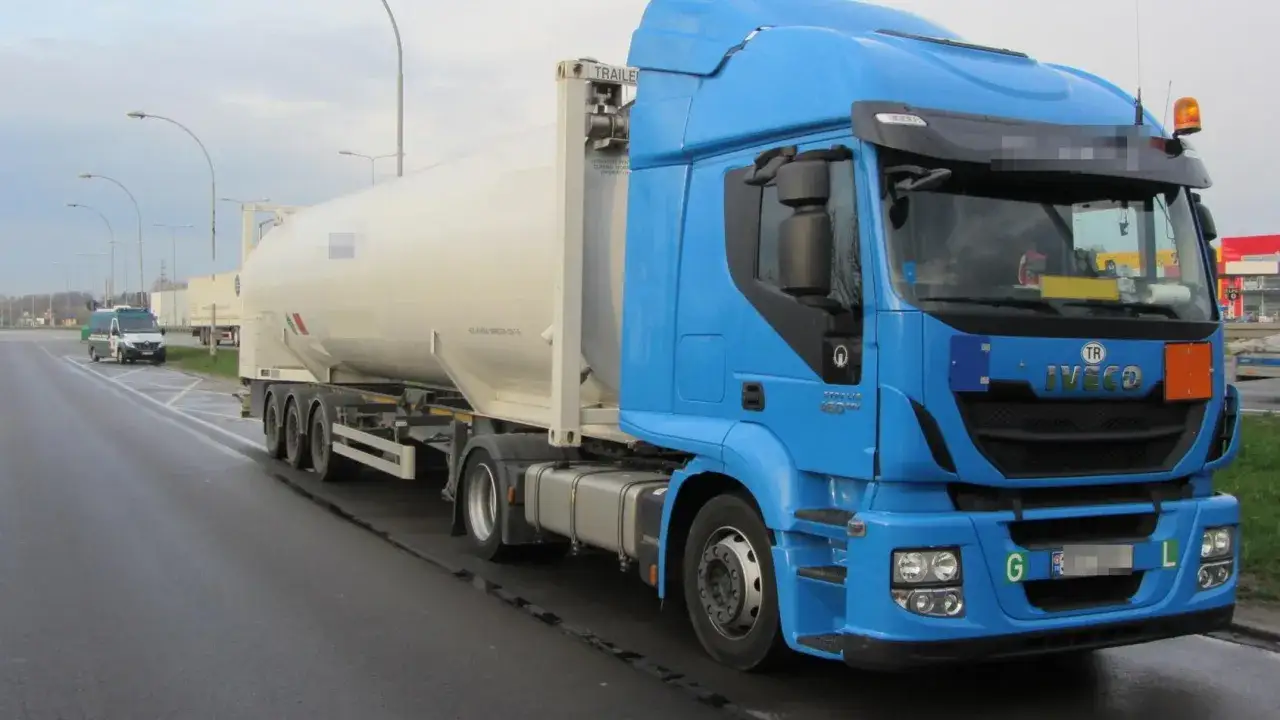 Niebieska ciężar&oacute;wka Iveco z cysterną do transportu towar&oacute;w niebezpiecznych na drodze.