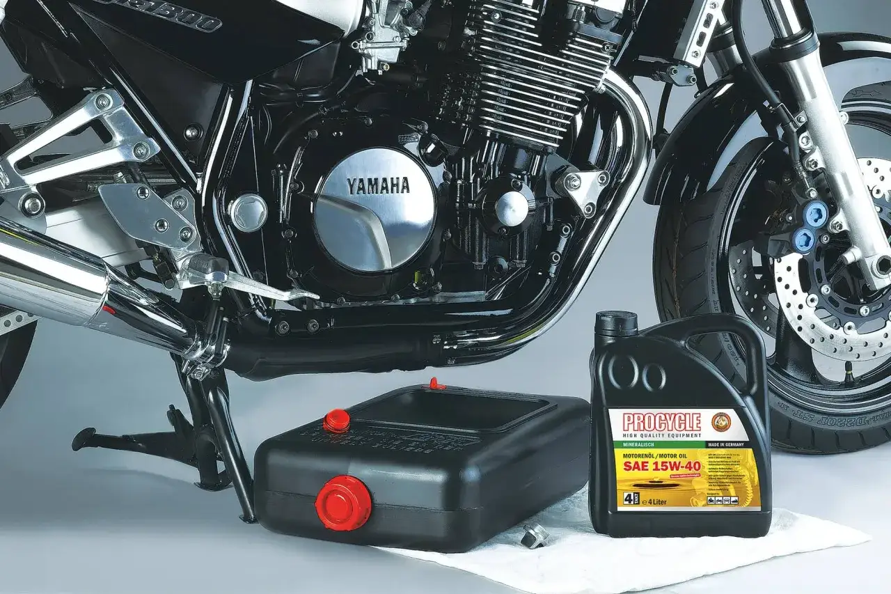 Gotowy do wymiany oleju w motocyklu Yamaha. Nowy olej Procycle SAE 15W-40 czeka obok miski na zużyty płyn.