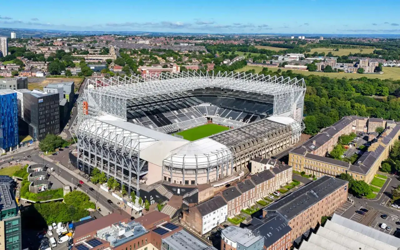 Stadion St. James' Park w Newcastle, symbol nadziei na nowe Newcastle transfery, otoczony miejską zabudową i zielenią.