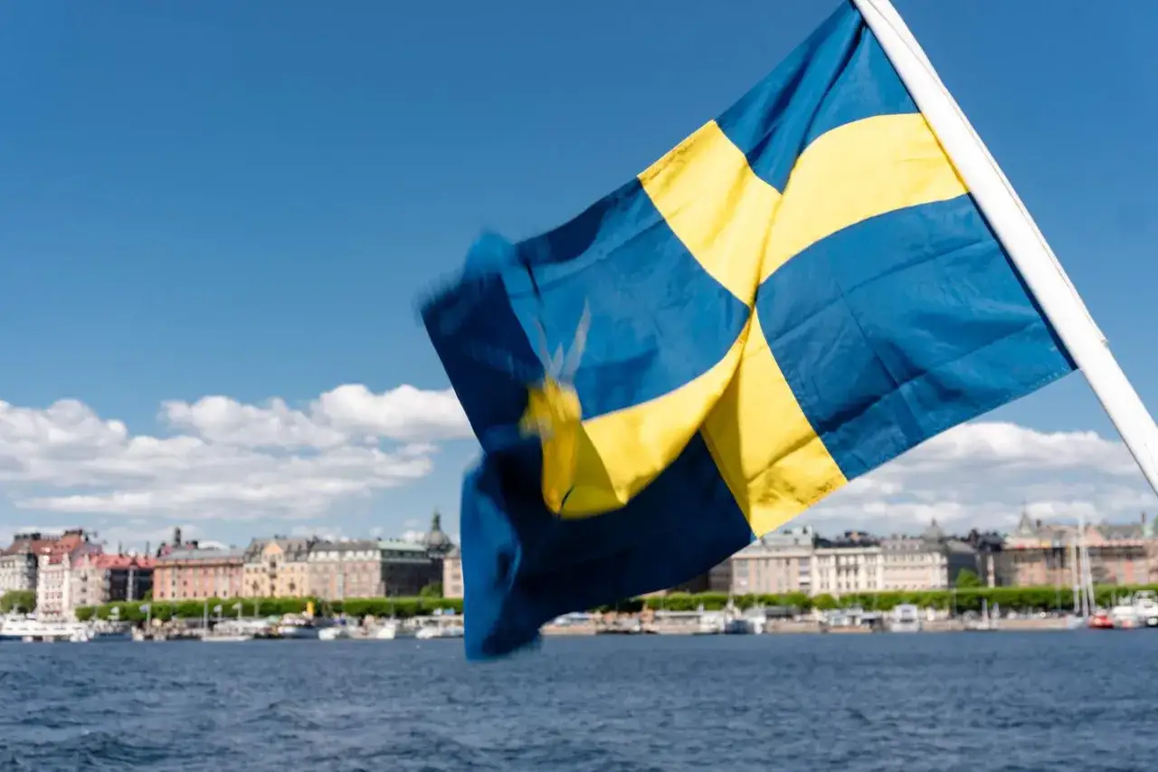 Svenska flaggan vajar i vinden med Stockholm i bakgrunden. En perfekt dag att vara ledig på nationaldagen och njuta av utsikten.