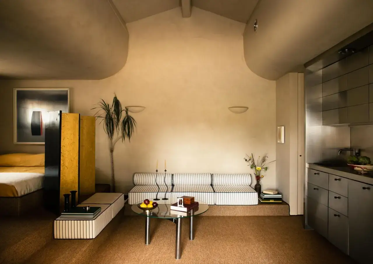 Salon moderne avec un canapé rayé, une table basse en verre et un **effet peinture à la chaux** sur les murs.