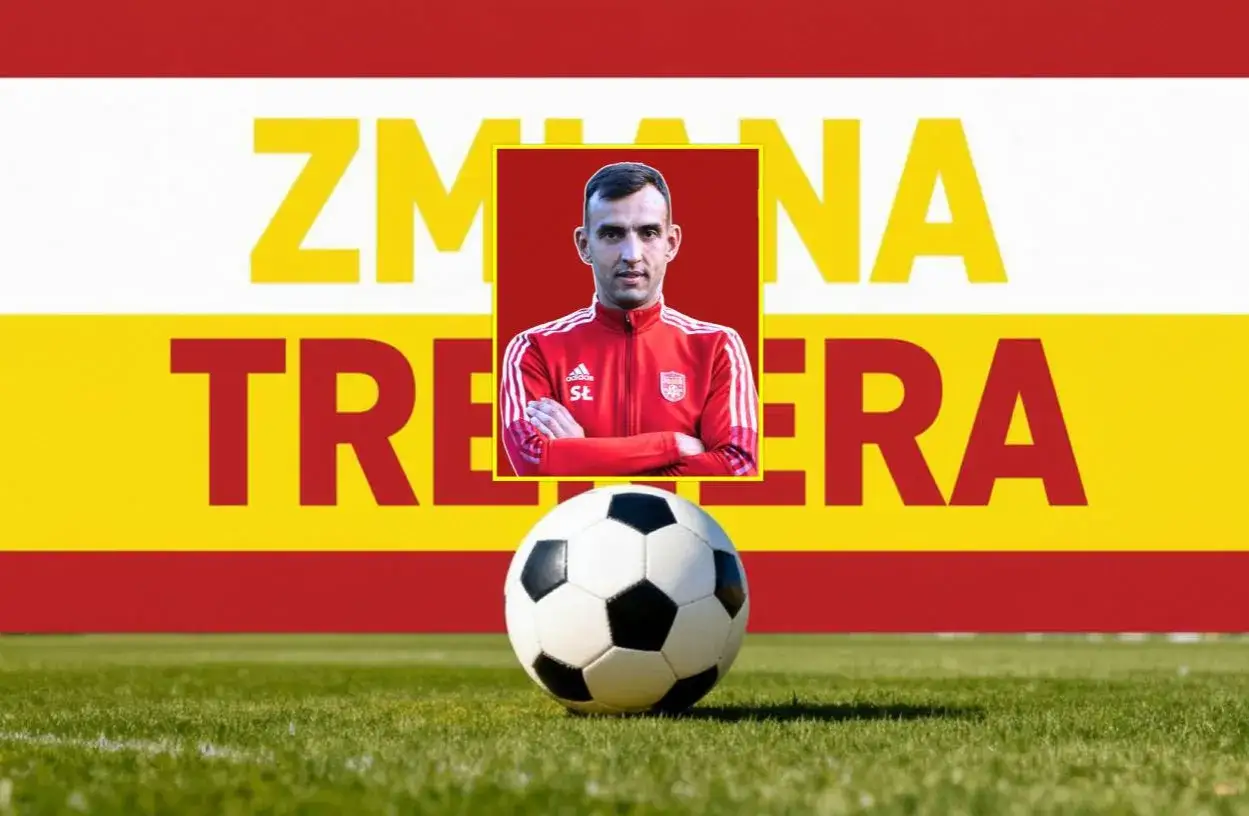 Trener w czerwonej bluzie, z rękami skrzyżowanymi na piersi, na tle napisu