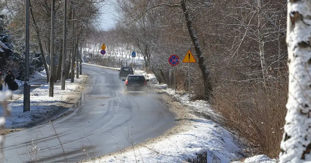 Śnieg i lód na drodze na Słowacji, samochody na oponach zimowych ostrożnie pokonują zakręt.