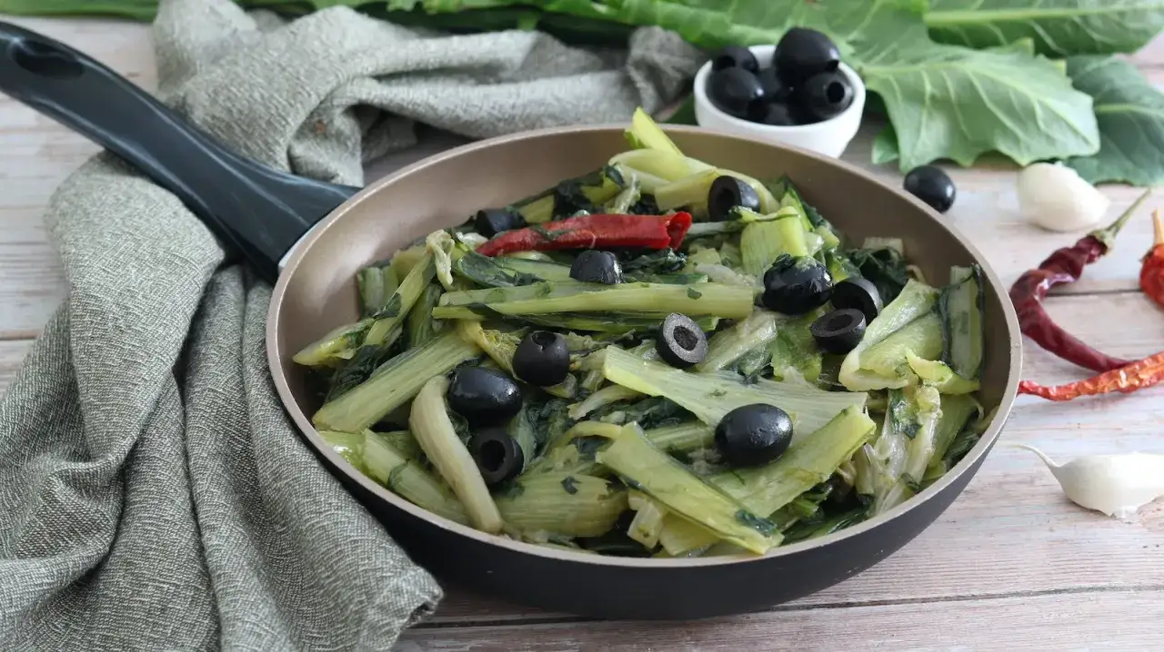 Catalogna verdura saltata in padella con olive nere e peperoncino. Un contorno saporito e salutare.
