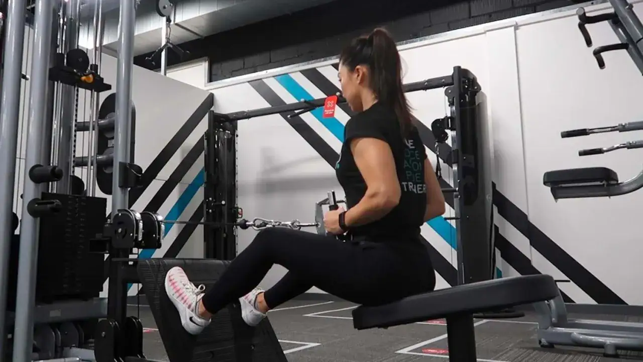 Kvinna utf&ouml;r sittande rodd p&aring; gymmaskin.