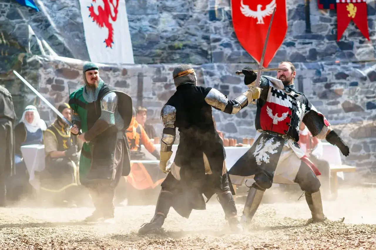 Zwei Ritter im Kampf bei Ritterspiele Schloss Burg. Staub wirbelt auf, w&auml;hrend sie mit Schwertern aufeinander losgehen.