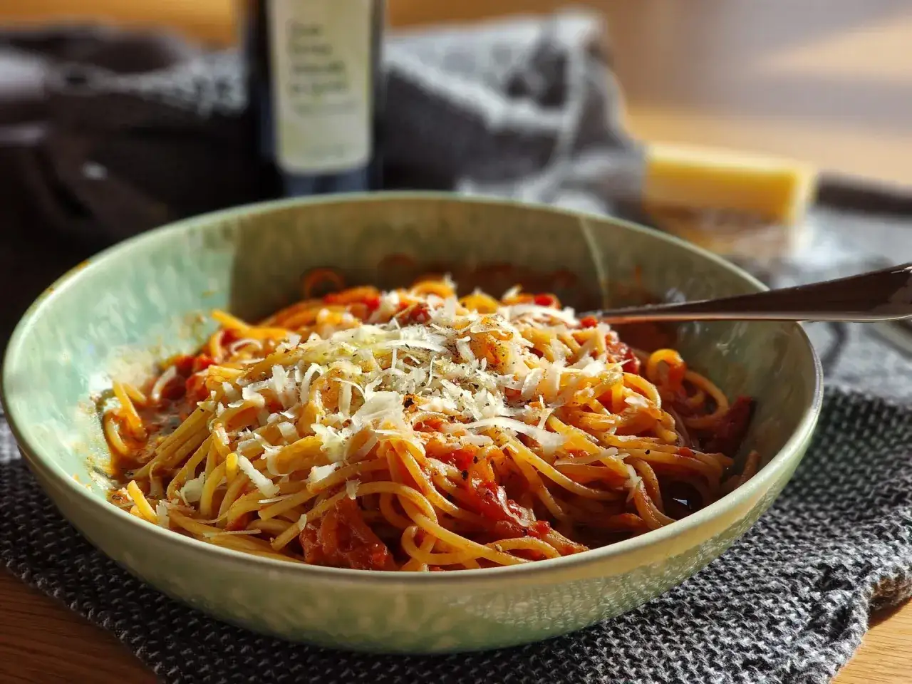 Eine Sch&uuml;ssel Spaghetti Amatriciana alla Nonna, garniert mit geriebenem Parmesan und schwarzem Pfeffer.