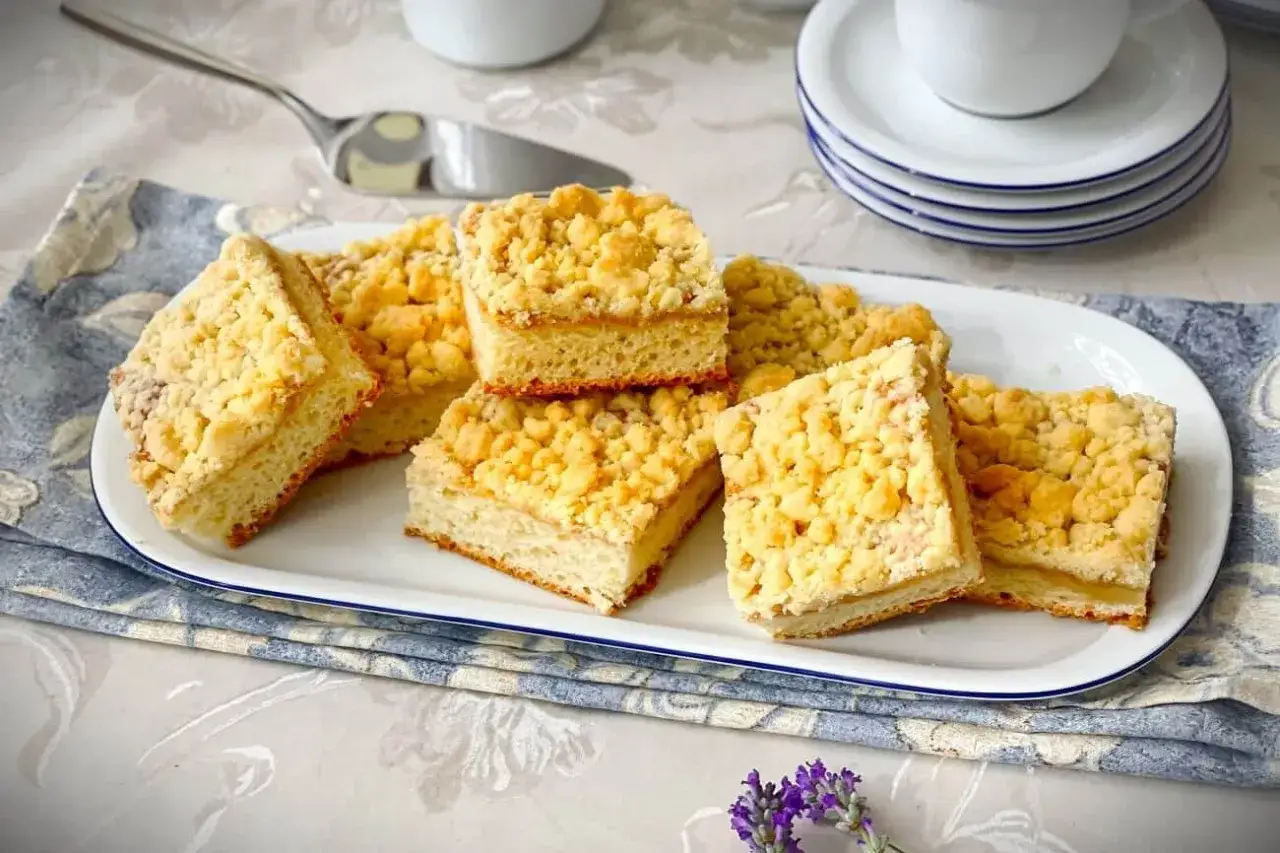 Saftiger Streuselkuchen vom Blech, in Quadrate geschnitten, auf einer Platte angerichtet. Perfekt zum Kaffee!