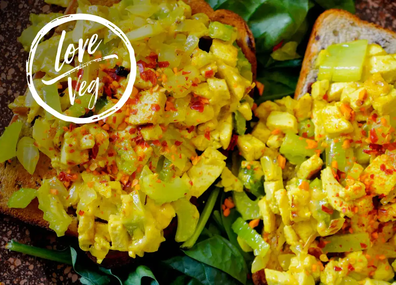 Delicioso revuelto de tofu con verduras y especias sobre tostada integral. ¡Amor por lo vegano!