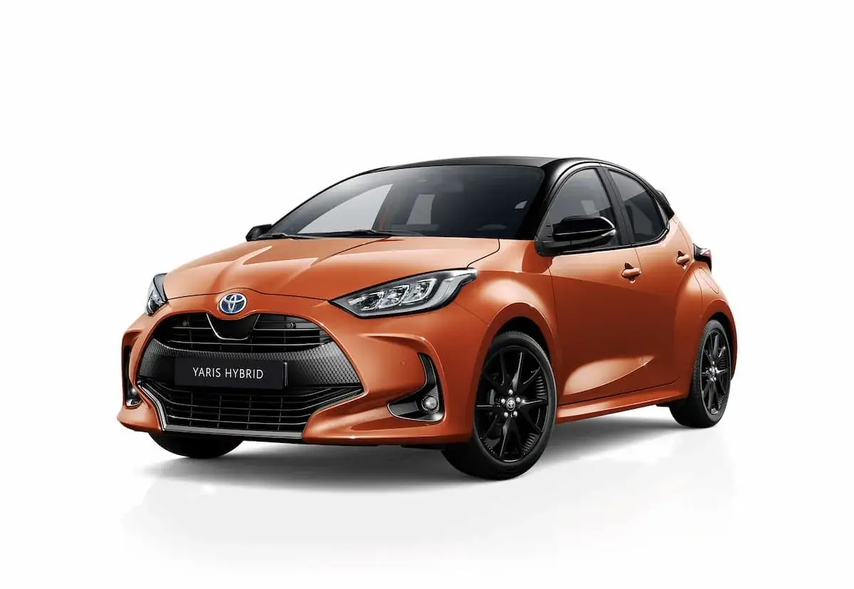 Toyota Yaris Hybrid naranja con llantas negras. Asegúrate de mantener la presión de los neumáticos correcta para un viaje seguro.