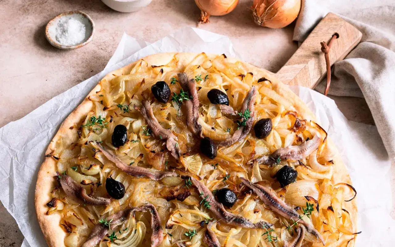 Pissaladi&egrave;re sur p&acirc;te bris&eacute;e ou feuillet&eacute;e, garnie d'oignons caram&eacute;lis&eacute;s, d'anchois et d'olives noires. Un d&eacute;lice m&eacute;diterran&eacute;en.
