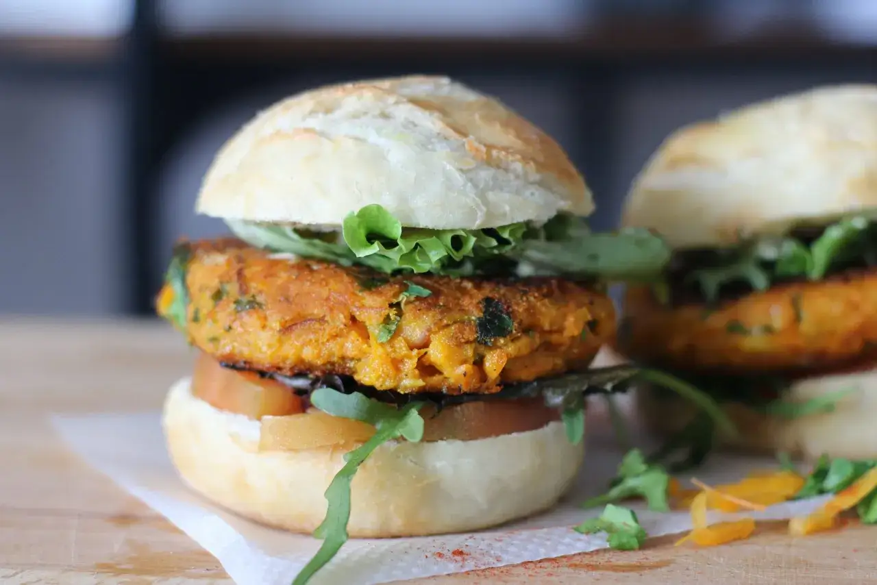 Deliciosa hamburguesa vegetal con pan artesanal, lechuga fresca y rodajas de tomate.