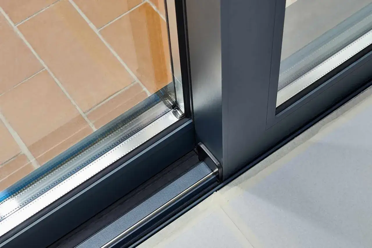 Detalle de ventana corredera con perfil de aluminio. La baja conductividad térmica del aluminio es clave para el aislamiento.