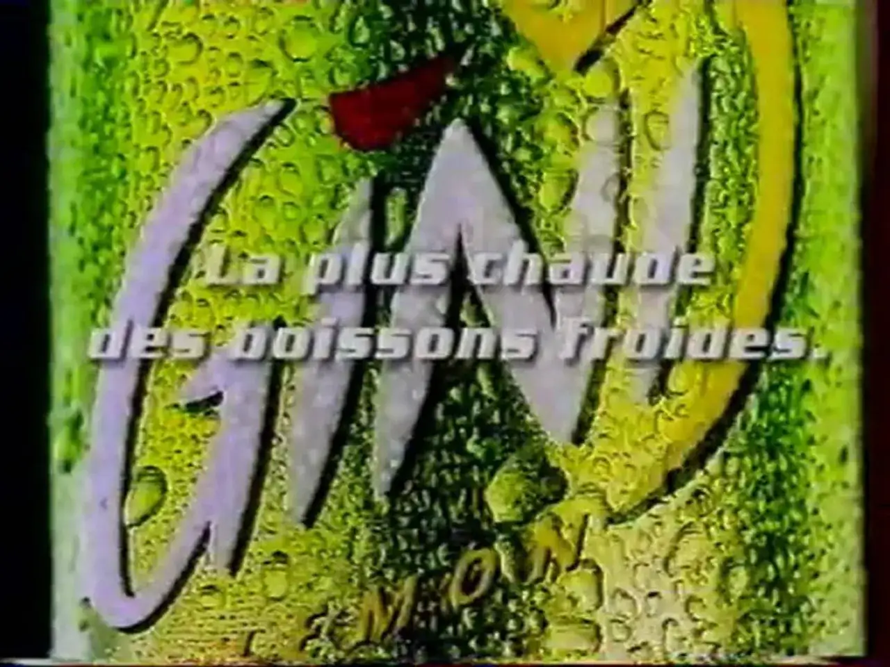 Une canette de boisson gazeuse verte et jaune, couverte de gouttelettes d'eau. Le logo
