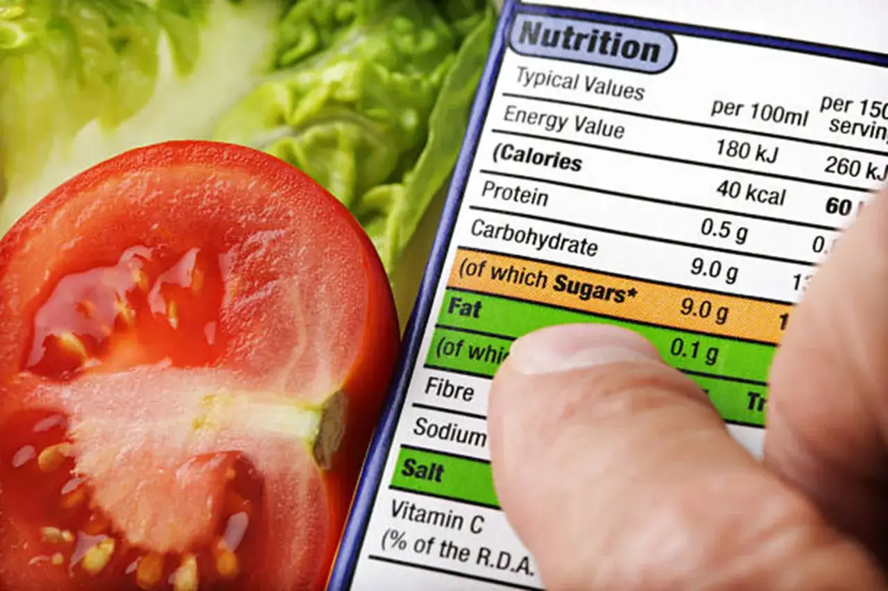 Pomidor i sałatka obok etykiety z informacją, ile kcal ma 1g białka. Na etykiecie widać 40 kcal na porcję.