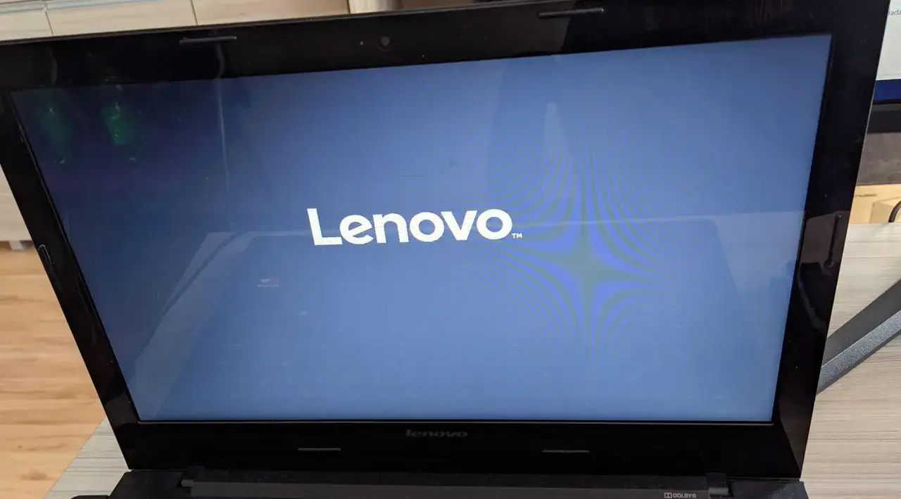 Czarny ekran w laptopie Lenovo. Widoczne logo marki na niebieskim tle.