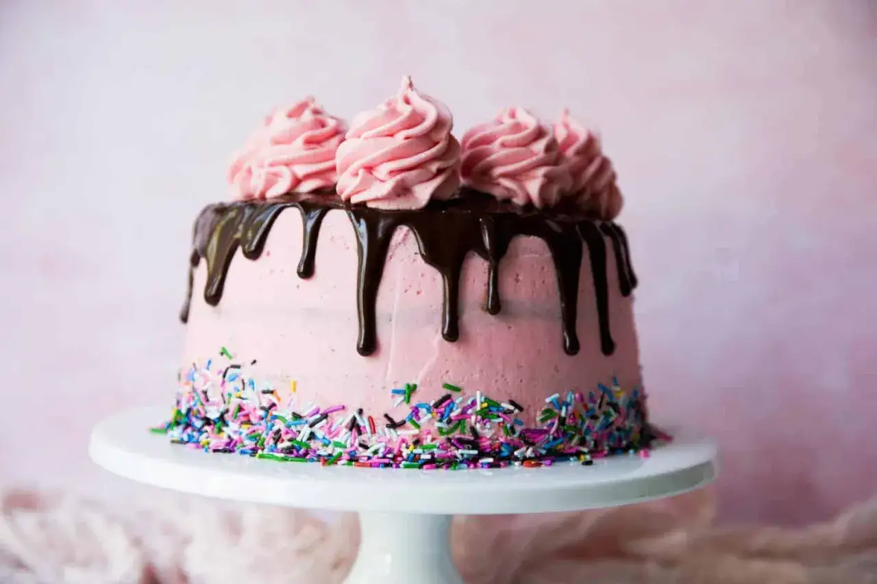 Eine moderne Erdbeertorte mit rosa Buttercreme, Schokoladenglasur und bunten Streuseln. Perfekt f&uuml;r jeden Anlass!