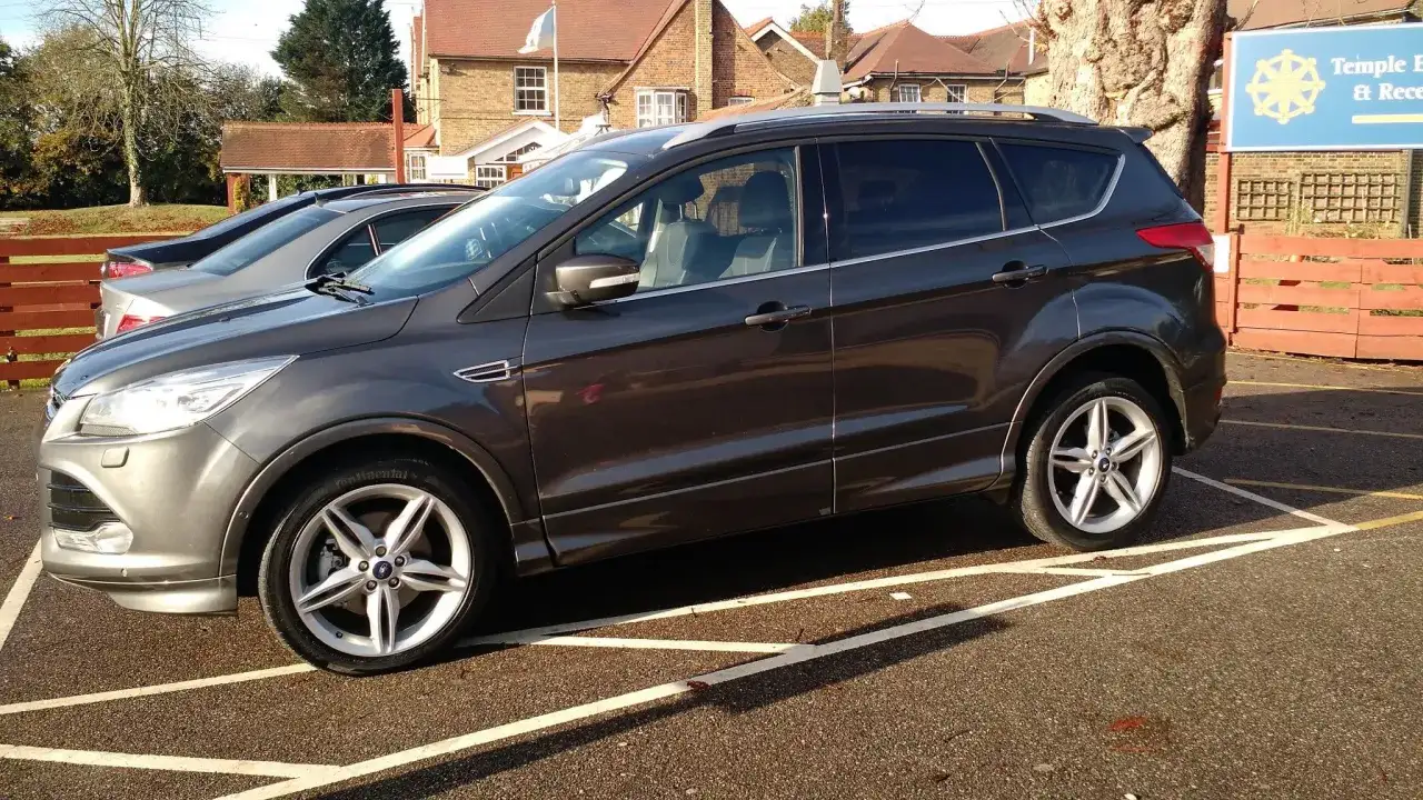 Ford Kuga usterka silnika brak mocy. Ciemnoszary SUV zaparkowany na parkingu, z widocznym uszkodzeniem silnika.