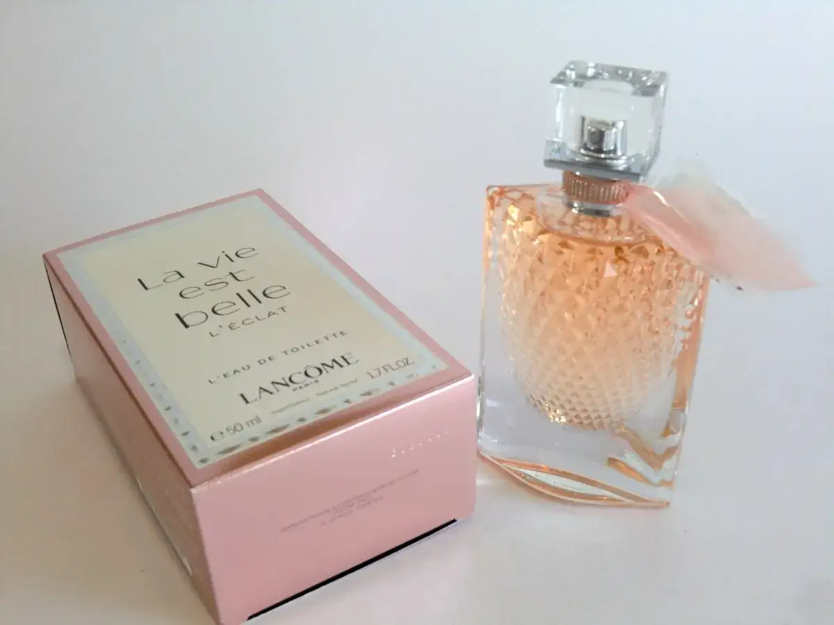 Perfumy Lancome La Vie Est Belle L'Eclat w różowym pudełku i szklanym flakonie z delikatną wstążką.