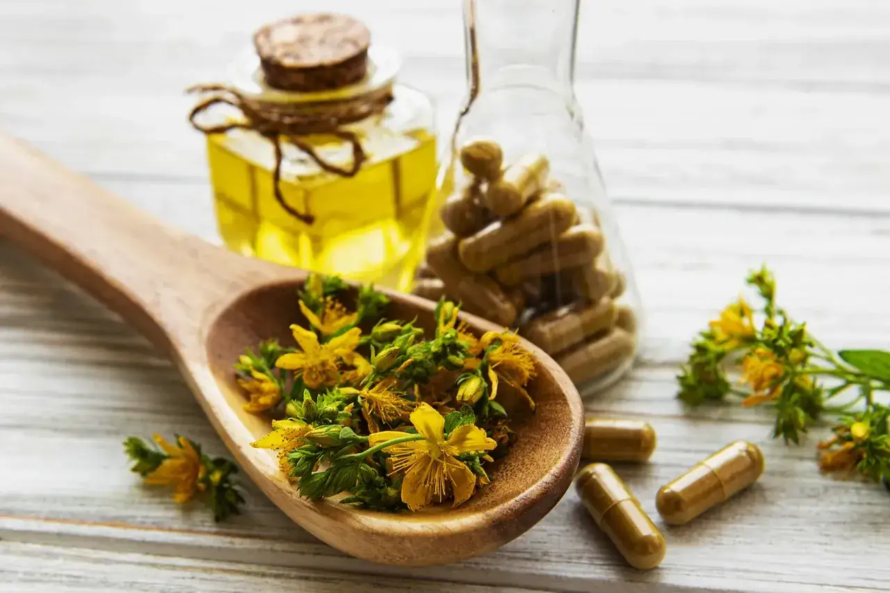 Johanniskraut-Bl&uuml;ten auf L&ouml;ffel, &Ouml;l und Kapseln. Die Wirkung von Johanniskraut auf die Psyche wird hier dargestellt.