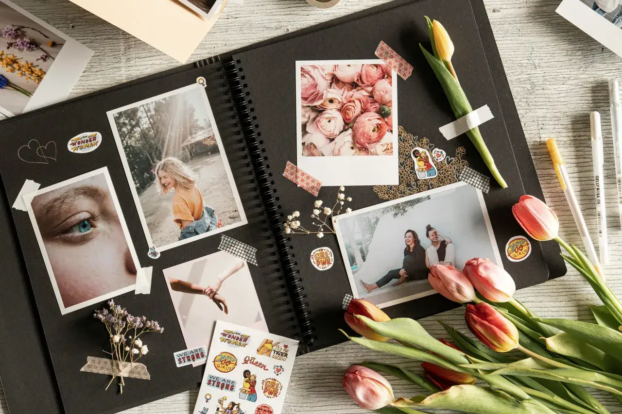Inspiracja, jak zrobić album na zdjęcia: czarny szkicownik z polaroidami, naklejkami 