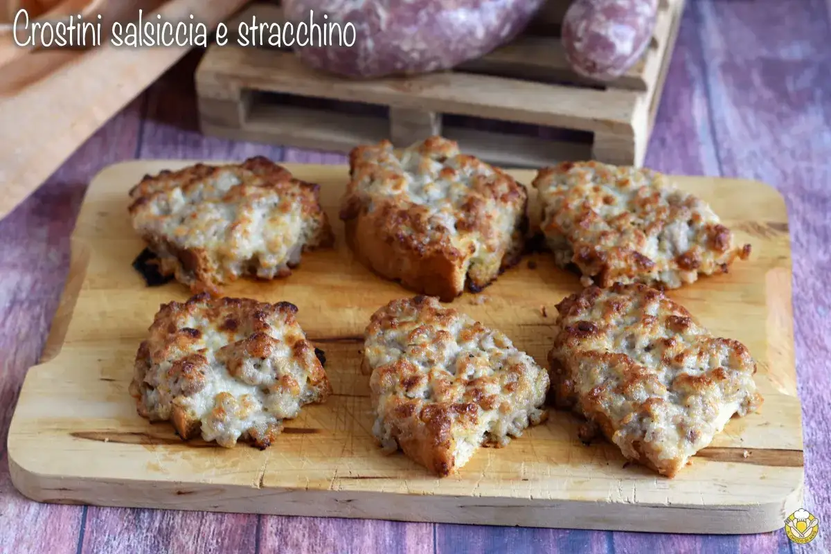 Sei crostini salsiccia e stracchino dorati e filanti, pronti per essere gustati.