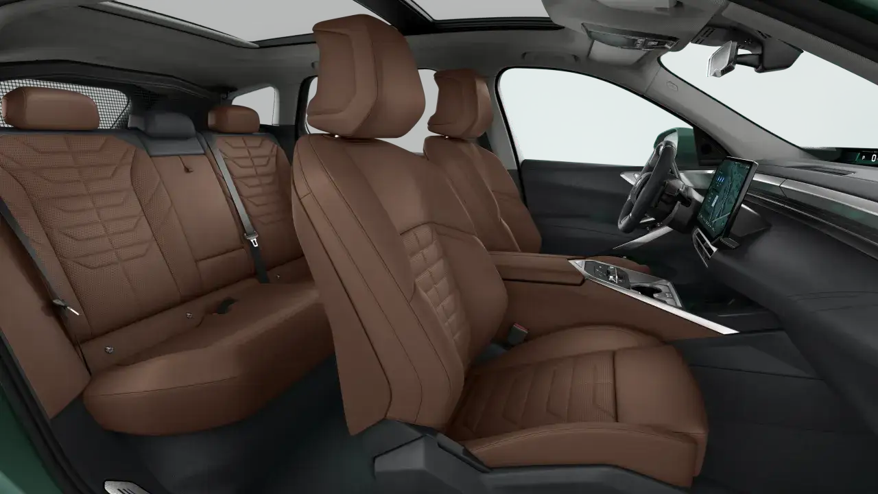 Wnętrze nowego BMW X5 z brązową skórzaną tapicerką i nowoczesnym panelem multimedialnym.
