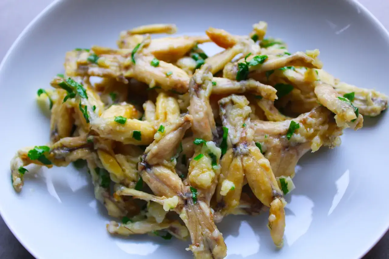 Une assiette de cuisses de grenouille saut&eacute;es &agrave; l'ail et au persil, un plat d&eacute;licieux.