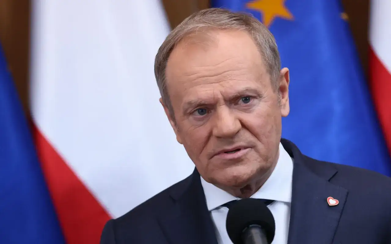 Donald Tusk przed mikrofonem, na tle flag Polski i UE. Czy to wyjaśnia, dlaczego prezydent Andrzej Duda unika wspólnych konferencji prasowych z premierem?