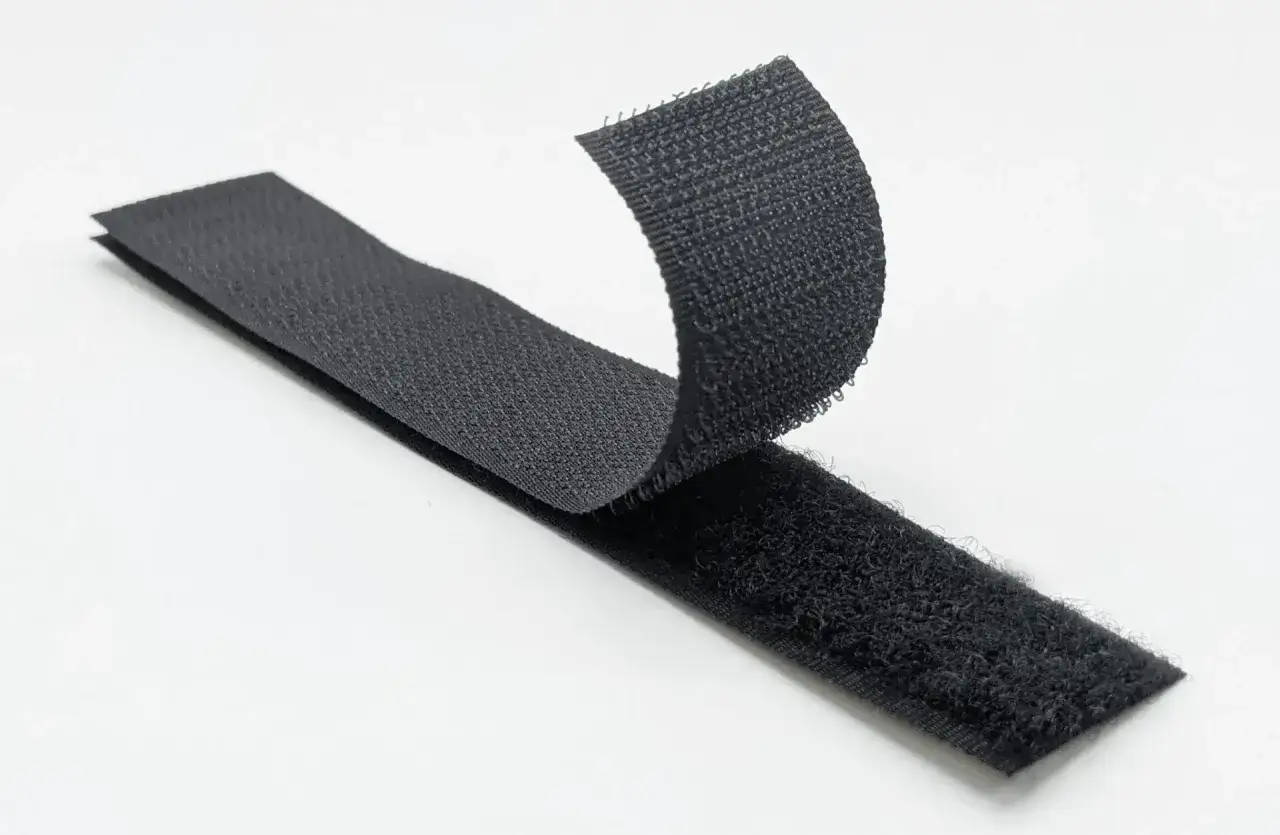 Cintas de velcro negro separándose. Inspirado en la naturaleza, George de Mestral es quién inventó el velcro.