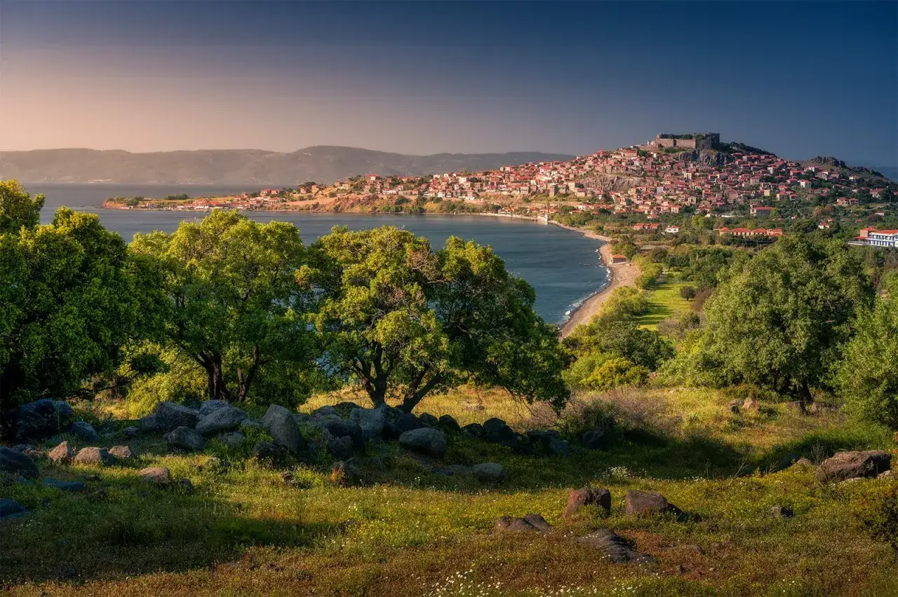 Widok na malowniczą zatokę i miasteczko na wzgórzu z zamkiem. Lesbos atrakcje zachwycają o każdej porze dnia.