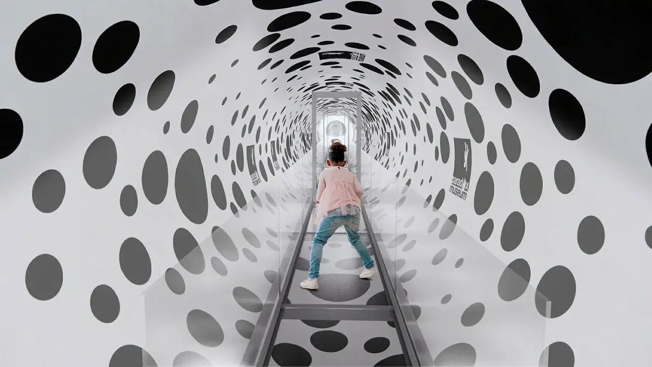 Barn g&aring;r genom en tunnel med prickar p&aring; Paradox Museum Stockholm, en optisk illusion.