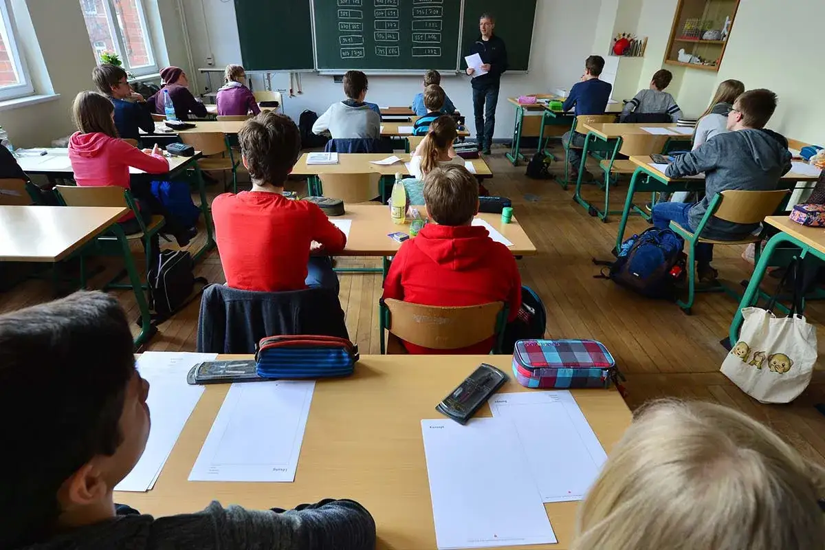Schüler im Klassenzimmer, die aufmerksam einem guten Lehrer zuhören.