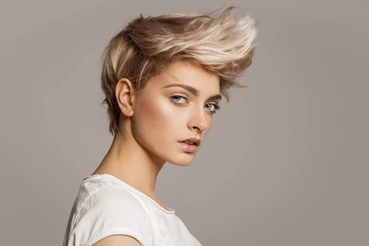Ein modernes Pixie Cut feines Haar mit blonden Strähnen, das Volumen und Textur zeigt.