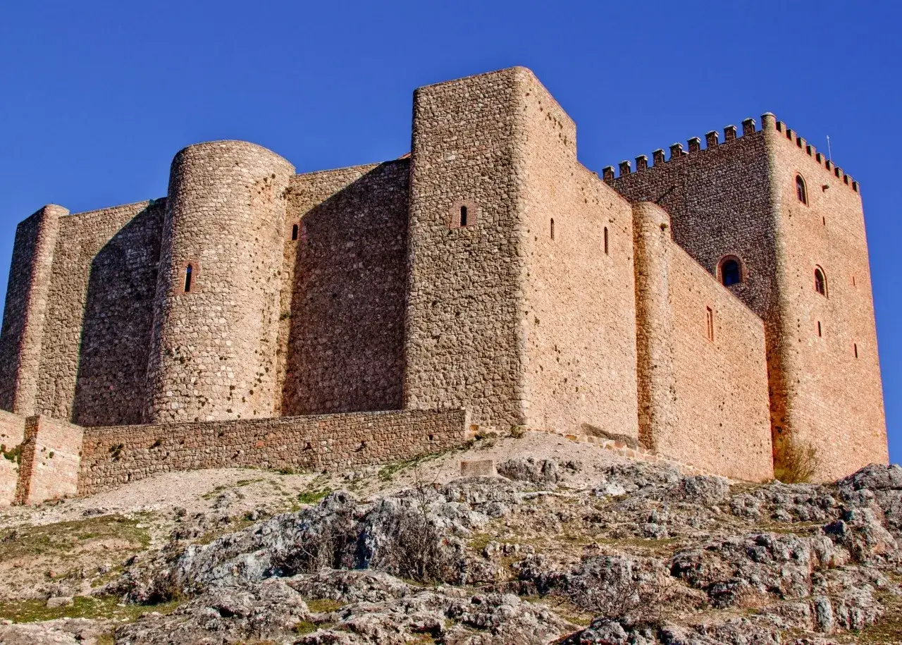 Imponente castillo de piedra en lo alto de una colina rocosa. Un lugar hist&oacute;rico que ver en Segura de la Sierra.