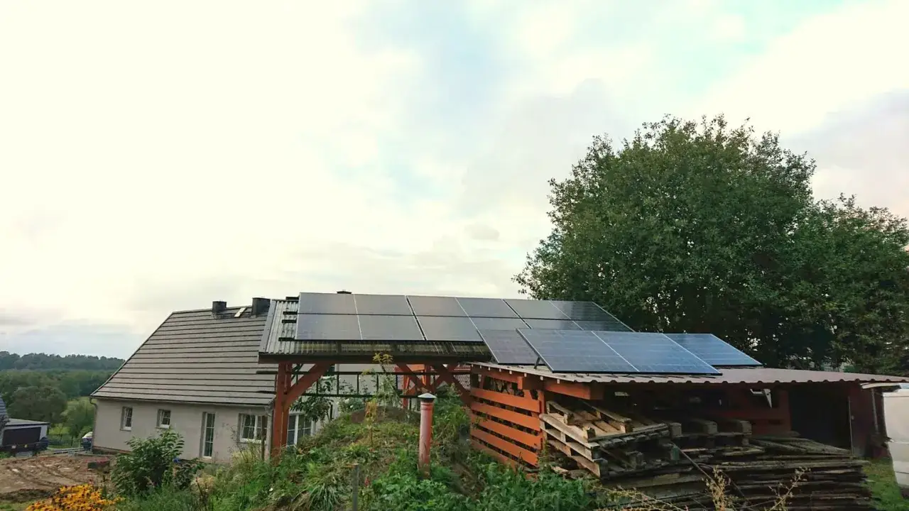 Panele fotowoltaiczne na dachu domu i wiaty zapewniają czyste powietrze i energię ze słońca.