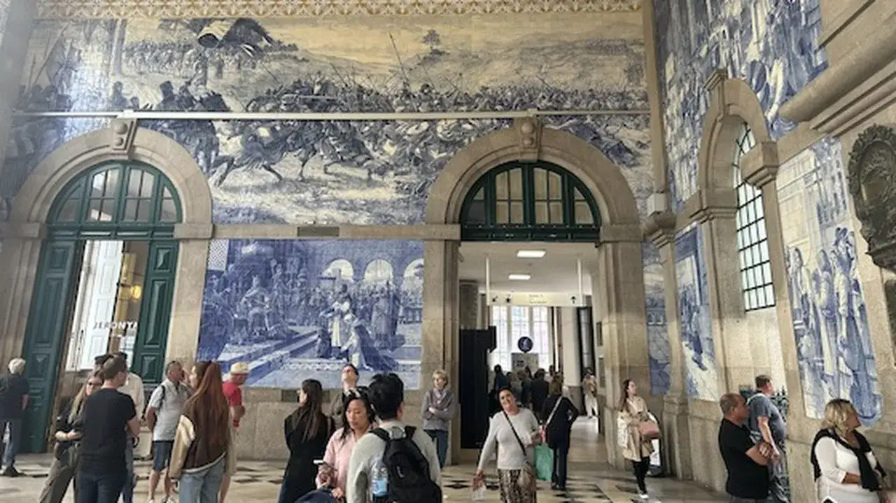 Im Bahnhof Porto bestaunen Reisende die beeindruckenden Azulejo-Fliesen, die historische Szenen darstellen.