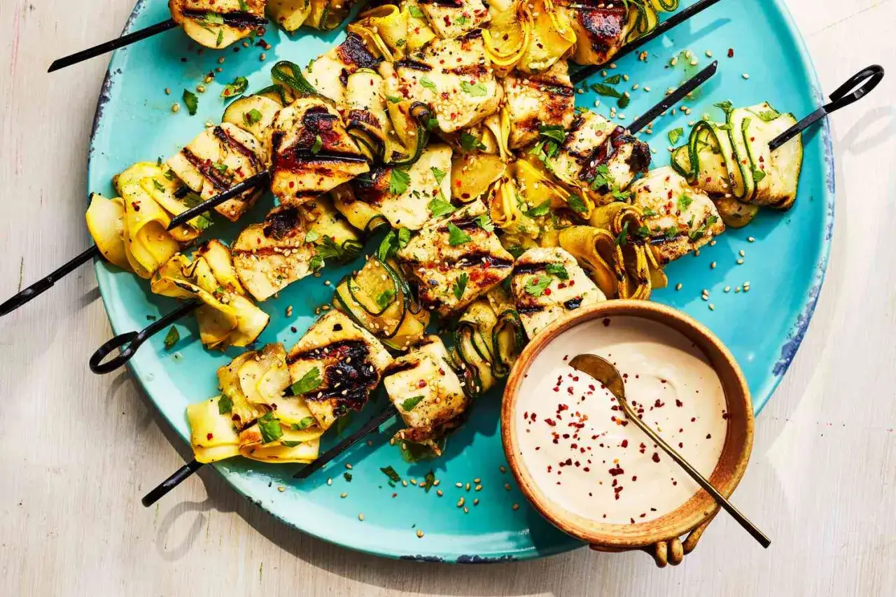 Brochettes de halloumi grill&eacute; et courgettes enroul&eacute;es, garnies de persil et de s&eacute;same. Un d&eacute;lice pour un barbecue estival.