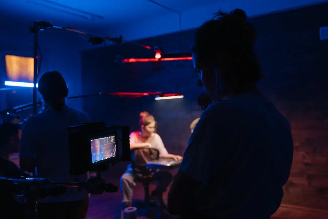 Na planie filmowym, gdzie rodzą się marzenia o tym, jak zostać reżyserem filmowym. Monitor kamery pokazuje ujęcie, a ekipa pracuje w niebieskim świetle.