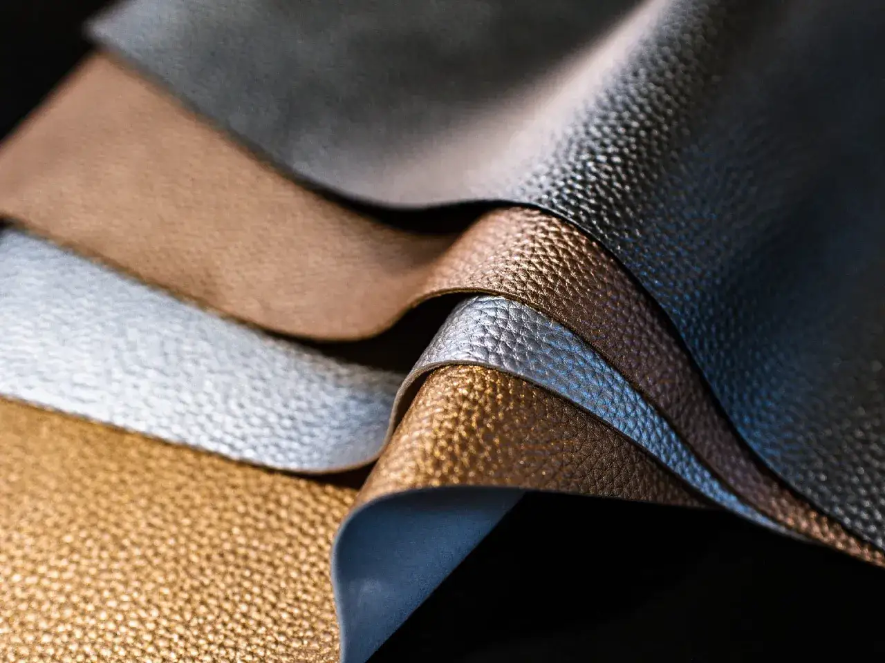 &Eacute;chantillons de cuir aux reflets m&eacute;talliques, montrant la texture et la richesse du tannage. Or, argent, bronze et gris.
