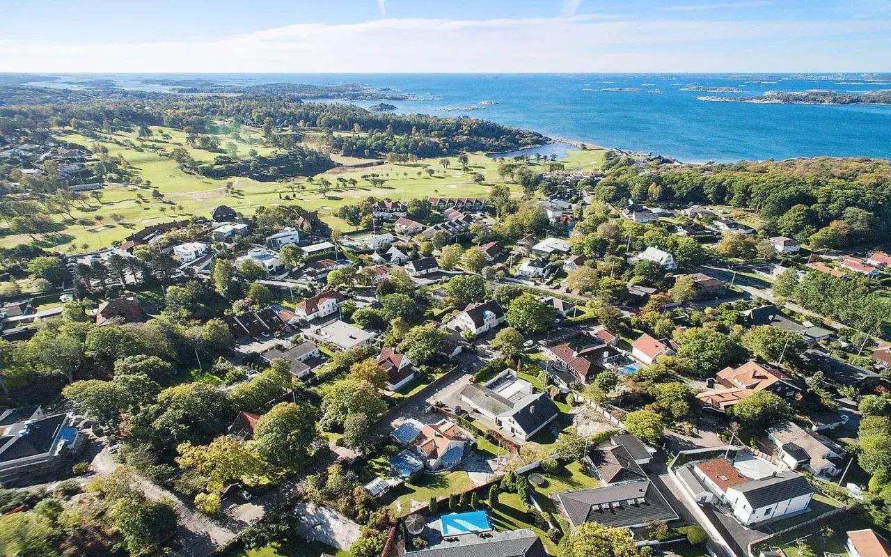 Vacker vy &ouml;ver ett villaomr&aring;de i Nya Hov&aring;s med golfbana och hav i bakgrunden.