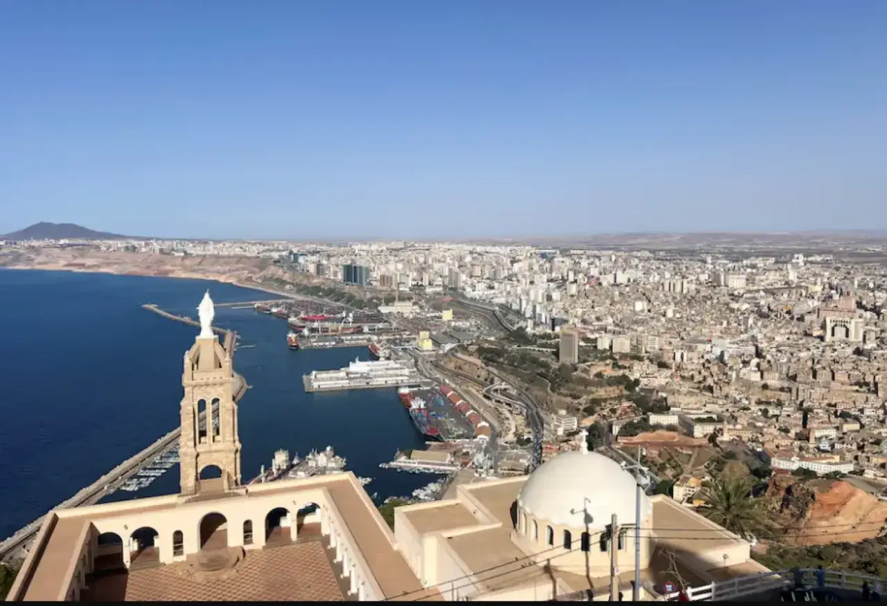 Blick &uuml;ber die weitl&auml;ufige oran stadt mit ihrem gesch&auml;ftigen Hafen, der K&uuml;ste und dem blauen Meer unter einem klaren Himmel.