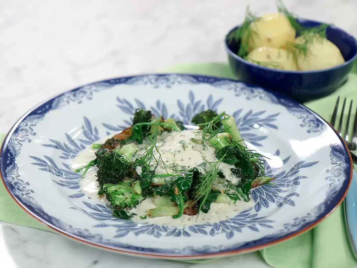 Koljarecept med krämig sås, broccoli och dill. Serveras med kokt potatis i en blå skål.