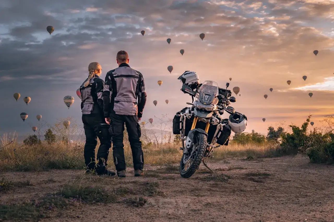 Para podróżuje motocyklem po Turcji, podziwiając wschód słońca i balony na gorące powietrze.