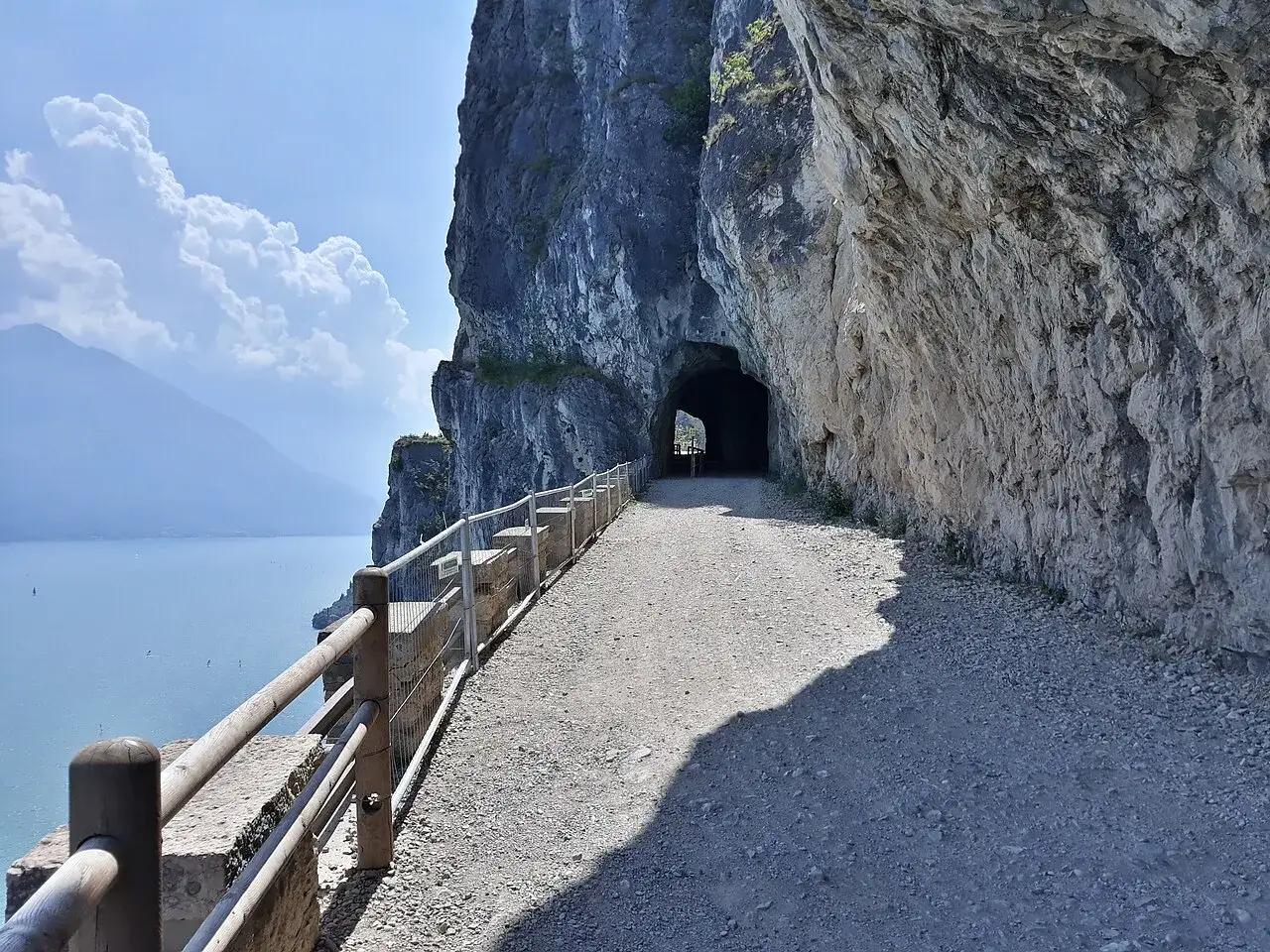 Il sentiero della Ponale, un percorso panoramico scavato nella roccia a picco sul lago, conduce verso un tunnel suggestivo.