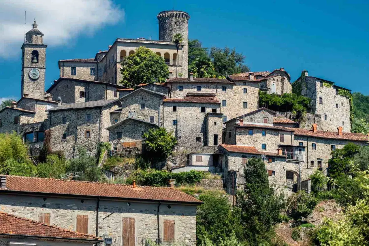 Antico borgo in pietra con torre campanaria e castello arroccato, uno dei suggestivi borghi vicino Pistoia.