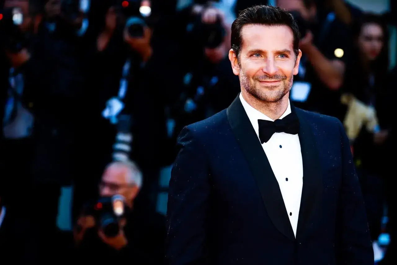 Bradley Cooper sports a classic tuxedo with a bow tie, proving you can wear a tie with a tux for a sharp look.